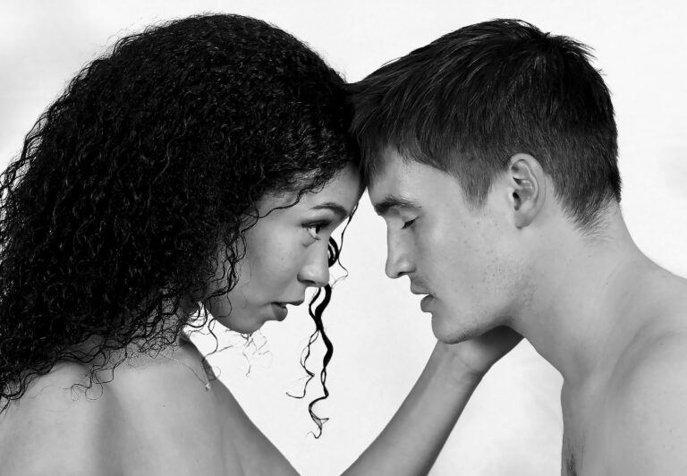 Woman holds mans face and stares intently