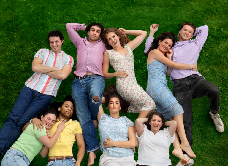 young people in colorful summer clothes lay on the grass